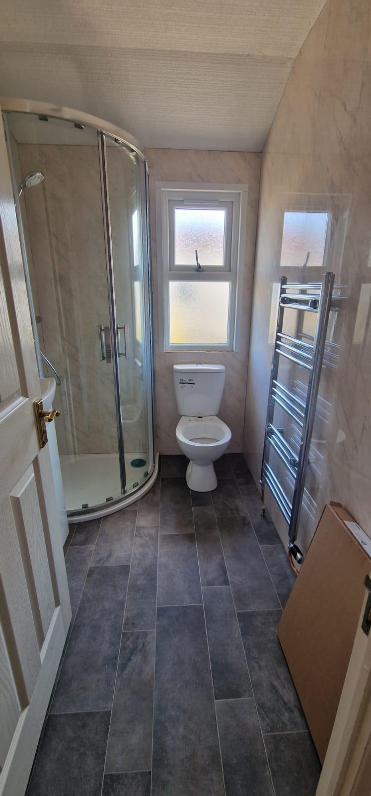Renovated park home bathroom with quadrant shower and tiled floor